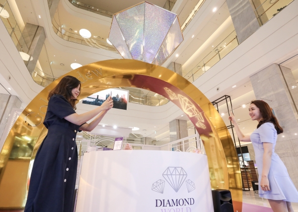 사진 = 25일 오전 현대백화점 판교점 1층 열린광장에서 고객들이 4M 높이의 다이아몬드 반지 모형이 설치된 '골든듀 다이아몬드 월드' 팝업스토어를 구경하고 있다.