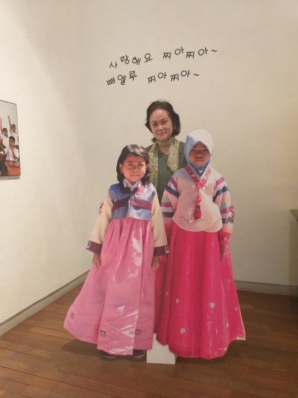 사진 = 지난달 19~25일 개최된 찌아찌아문화교류협회 사진전에서 정순겸 작가가 찌아찌아 아이들 사진과 기념 촬영을 하고 있다.