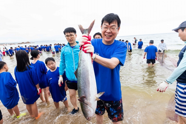 사진 = ‘Sh수협은행 제18회 사랑海 썸머페스티벌’에 참가한 고객 가족이 ‘맨손 물고기잡기’ 를 체험하며 즐거워하는 모습.