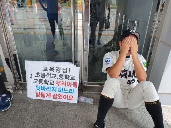 전북고창군 영선고 야구부 학부모회와 선수들이 전라북도 교육청 앞에서 야구부 해체 철회를 요구하며 집회를 하고 있는 가운데 한 선수가 주저앉아 있다.