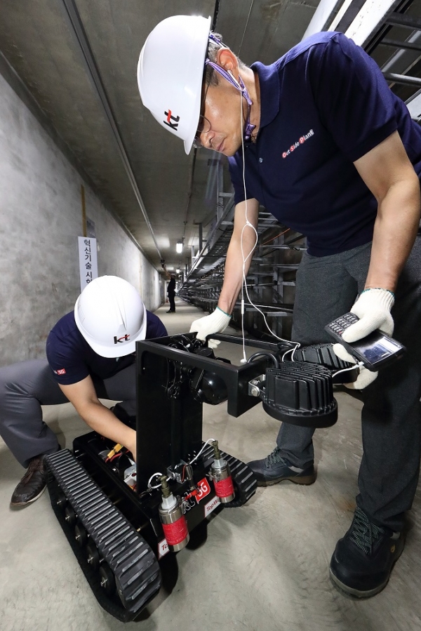 KT 네트워크부문 직원들이 통신구에 설치된 지상형 5G 로봇을 점검하고 있다.(사진 KT 제공)