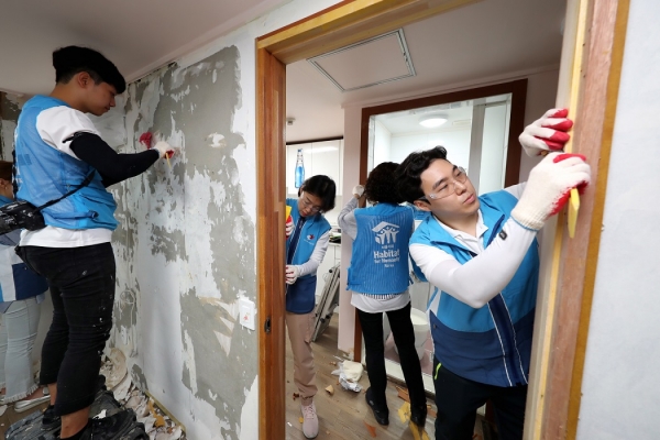 희망의 집 고치기 봉사활동에 나선 대우건설 직원들이 노후된 벽지를 제거하고 있다.(사진 대우건설 제공)