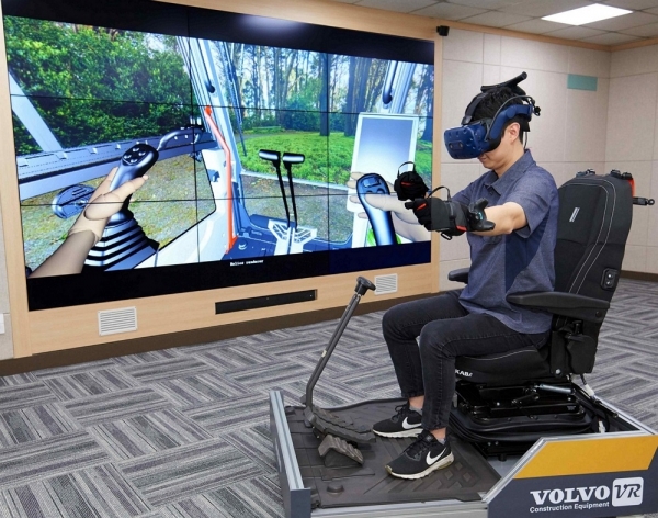 경남 창원 연구개발센터 직원이 인피니티 룸의 VR 기기를 착용하고 실제 작업현장과 유사한 가상체험환경에서 볼보 굴착기를 시연해 보고 있다.