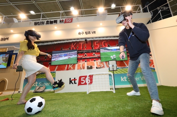 고객들이 KT 전시관에서 슈퍼VR 축구 게임을 체험하고 있다.