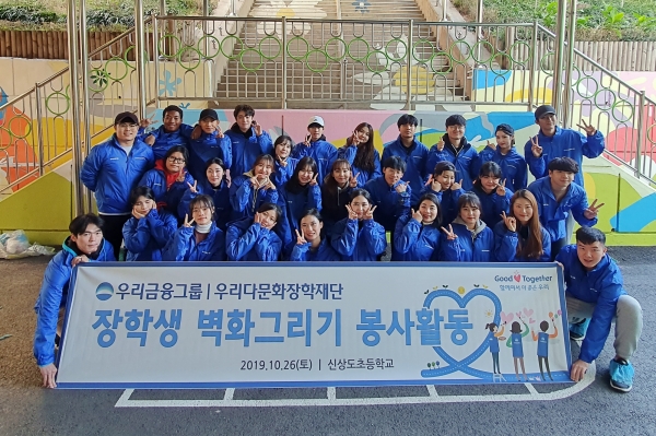 사진 = 우리금융그룹 우리다문화장학재단 대학생 40여명이 서울 신상도초등학교에서 벽화그리기 봉사활동 후 사진촬영을 하고 있다.