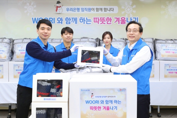 사진 = 손태승(오른쪽 첫번째) 우리금융그룹 회장이 지난달 25일 임직원과 함께 실시한 겨울용품 포장 봉사활동 사진. 해당용품은 아동복지기관으로 전달된다.