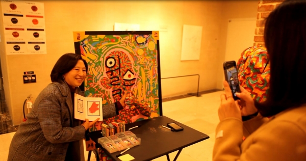 사진 = 직원들이 이랜드 가산사옥 1층에서 이름으로 그림을 그려주는 초명화 작품에 참여하고 사진을 찍는 모습
