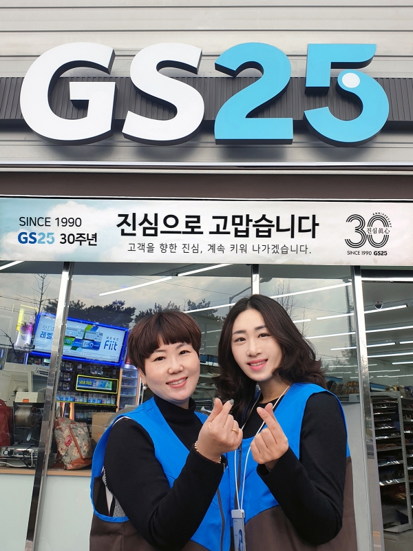 박윤정 GS25 호림공단점 경영주와 본부 영업담당 직원이 매장 앞에서 손으로 하트를 그려보이고 있다