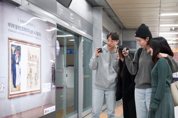 서울 지하철 6호선 공덕역에 마련된 세계 최초 5G기반 문화예술 공간 ’U+5G 갤러리’에 방문한 고객이 ‘U+AR’ 앱으로 작품을 체험하고 감상하고 있다.[사진 LG유플러스 제공]