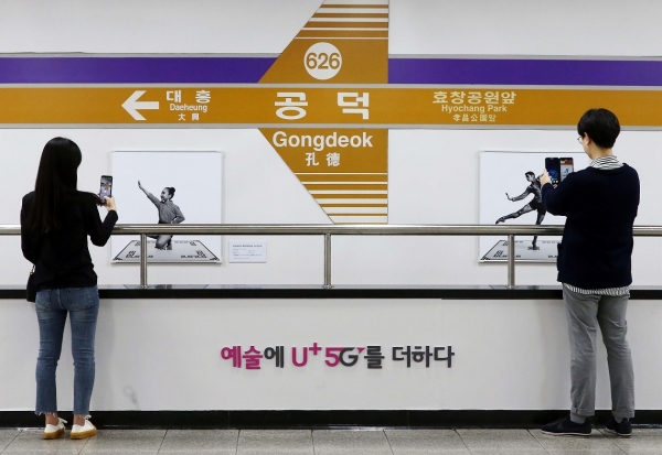 서울 지하철 6호선 공덕역에 마련된 세계 최초 5G기반 문화예술 공간 U+5G 갤러리에 방문한 고객이 U+AR 앱으로 작품을 체험하고 감상하고 있다.[사진 LG유플러스 제공]