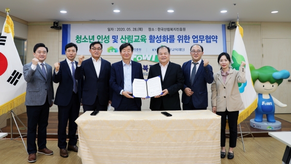 사진 = 한국산림복지진흥원과 청소년 인성함양을 위한 가족 프로그램 운영 협약을 체결하고 있다. (교보교육재단 제공)