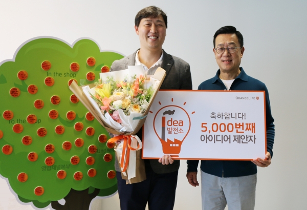 사진 = 서울 중구 순화동 오렌지센터에서 5000번째 아이디어를 제안한 오렌지라이프 직원과 정문국 사장이 기념촬영을 하고 있다. (오렌지라이프 제공)
