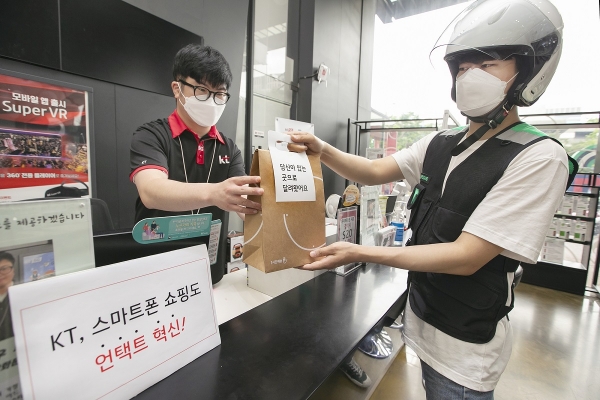 KT 대리점 직원이 부릉 라이더에게 ‘1시간배송’ 서비스를 통한 핸드폰 배송을 요청하고 있다.[사진 KT 제공]