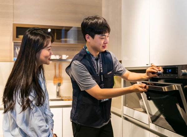 사진) 삼성전자서비스 수리 엔지니어가 고객에게 오븐 사용방법을 설명하고 있는 모습
