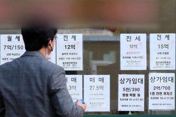 사진 = 서울 시내 한 공인중개사사무소 앞에서 30대 남성이 게시글을 확인하는 모습 (뉴스1 제공)