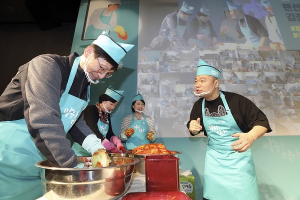 KT 김형욱 미래가치TF장과 이선주 지속가능경영단장이 랜선 김장나눔 행사에 참여해 김장을 담그며 진행자와 이야기를 나누고 있다.
