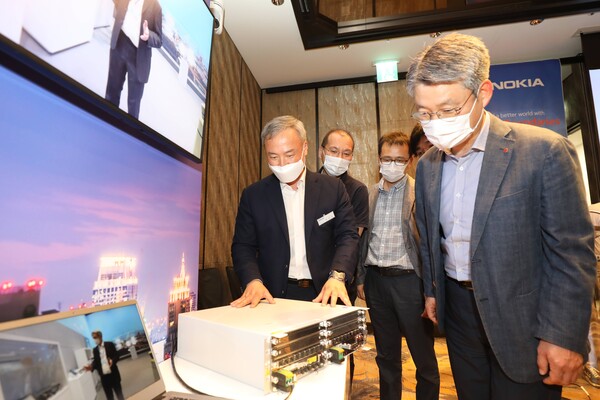 권준혁 LG유플러스 네트워크부문장(맨 오른쪽)이 김우조 노키아 전무로부터 노키아의 신형 기지국 장비에 대해 설명을 듣고 있다(사진=LG유플러스 제공)